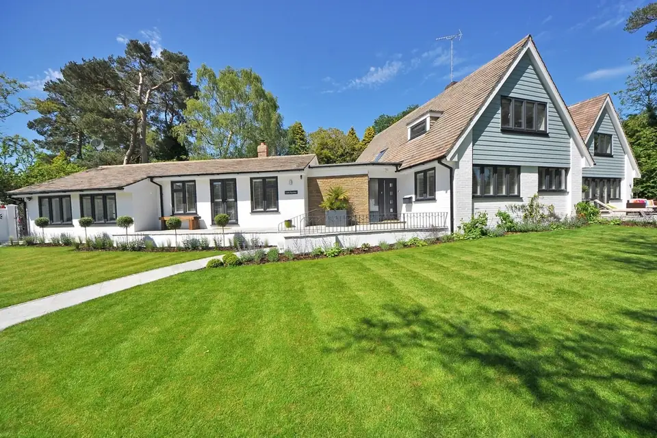 House with a green lawn under a clear summer sky
